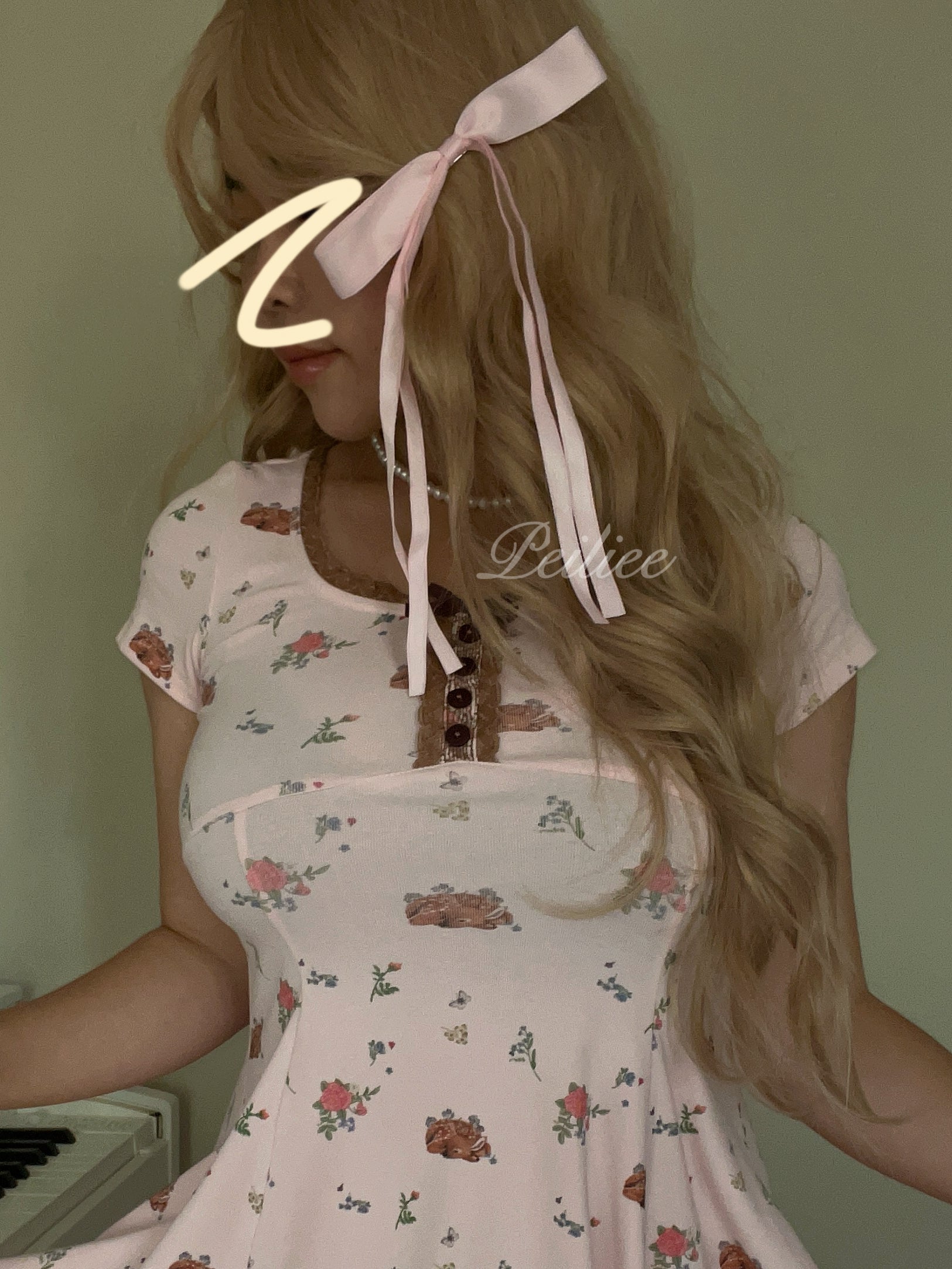 girl wearing a long curly wig with floral dress with a bow in their hair against a plain background