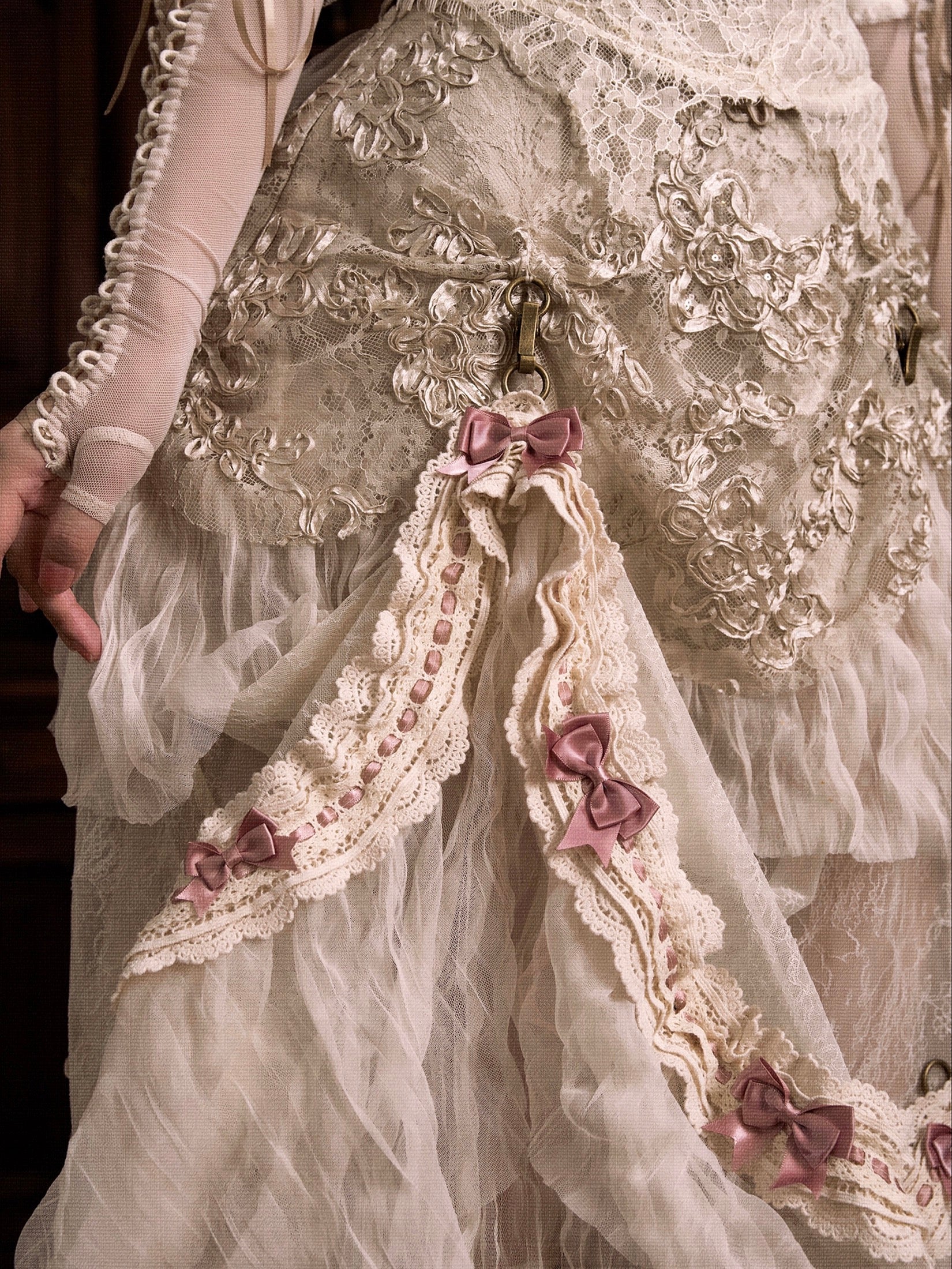 Close-up of a decorative garment with lace and ribbons