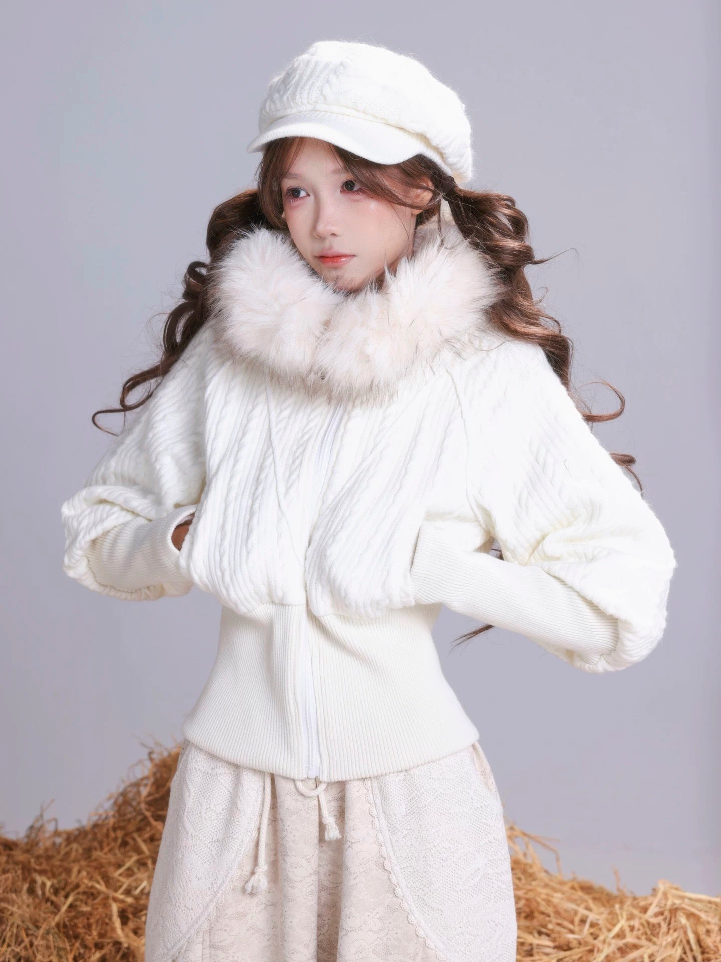 A Girl wearing a white hoodie outfit with faux fur trim on a plain background