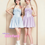 Two young women wearing glittery pastel-colored minin dresses standing in front of a beige archway.