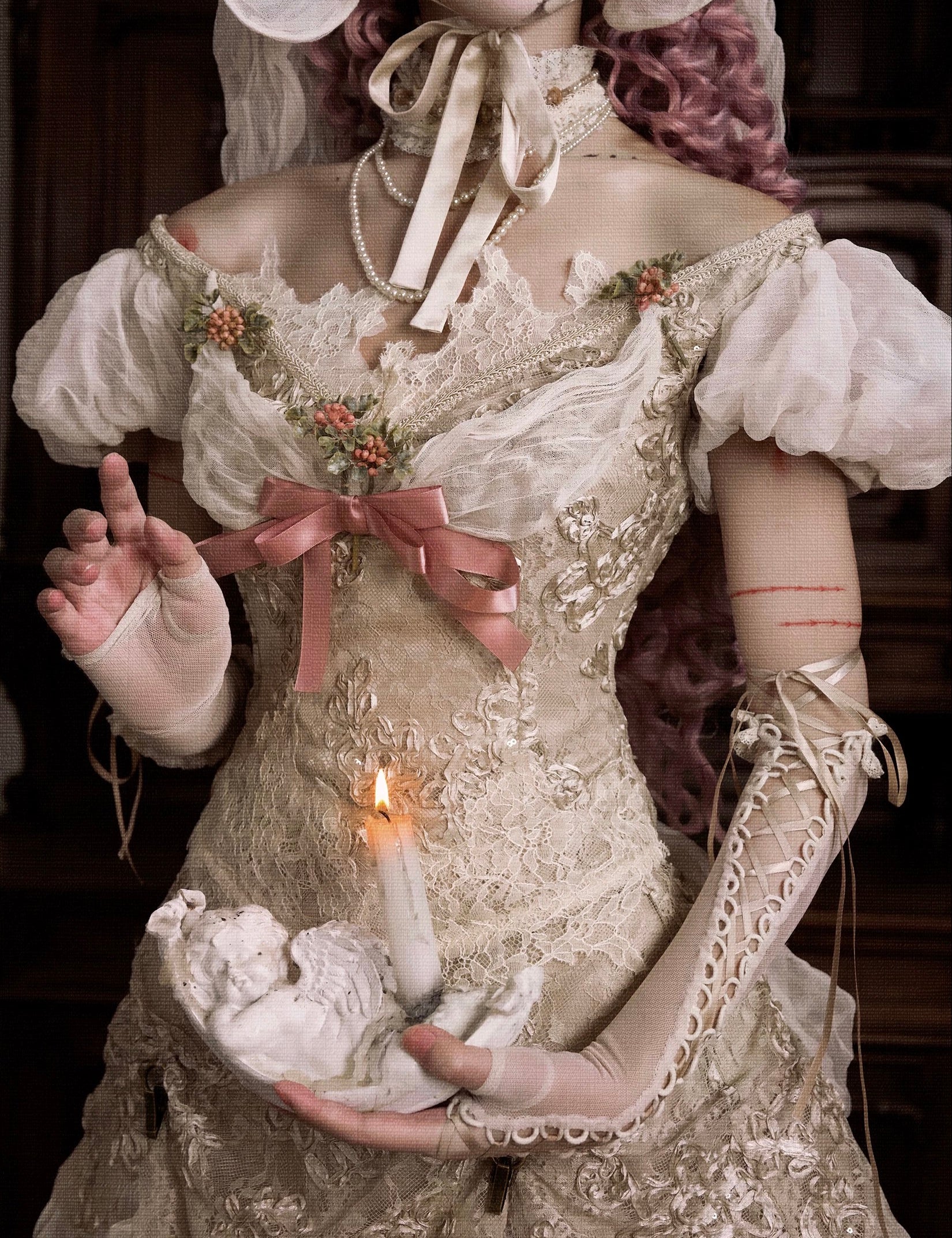 girl in an vintage floral bridal dress holding a candle, with a dark background. Gothic fashion for halloween wear.