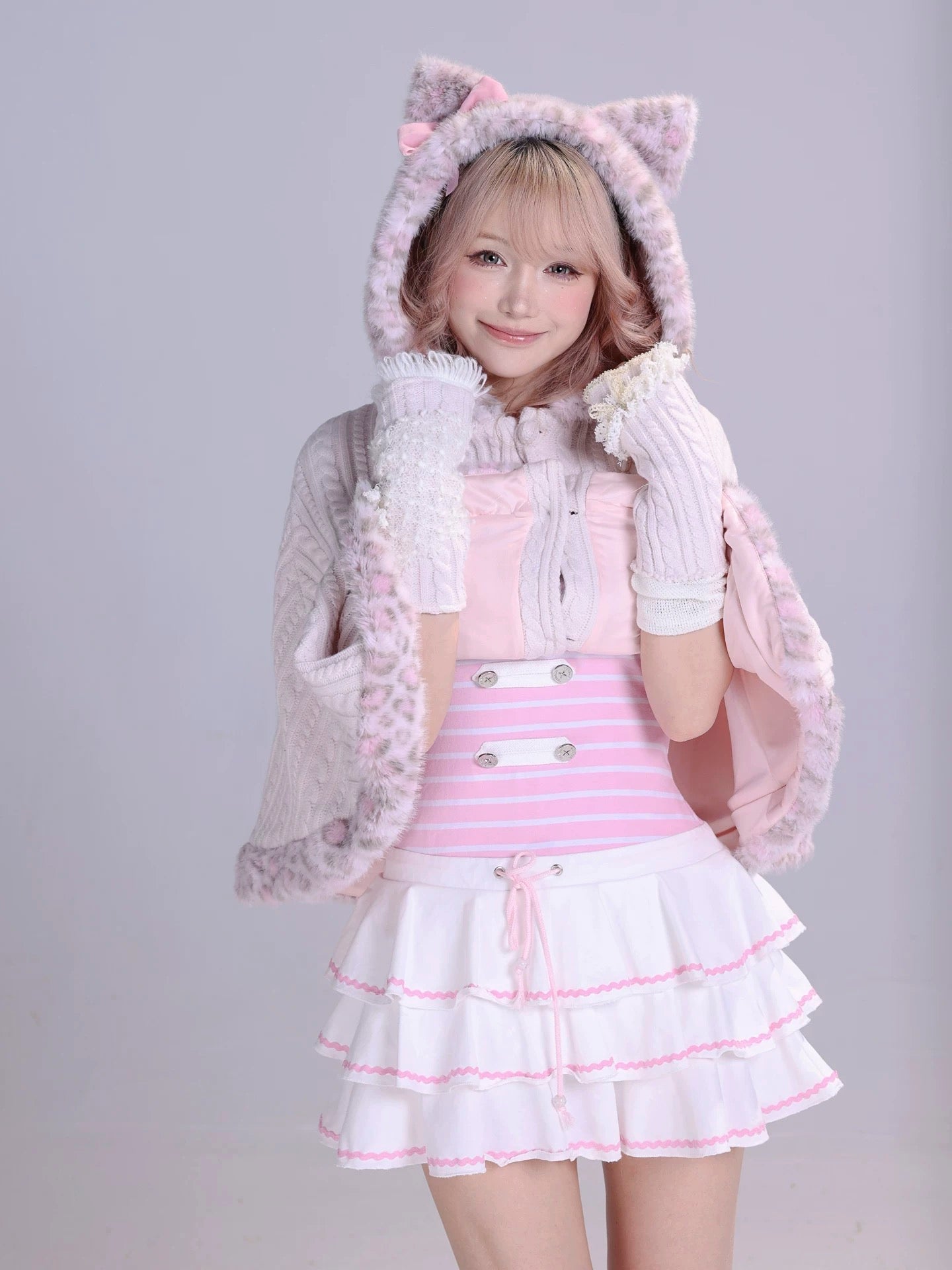 Girl wearing a pink and white fluffy faux fur cape with cat ears and kawaii pastel pink mini  dress