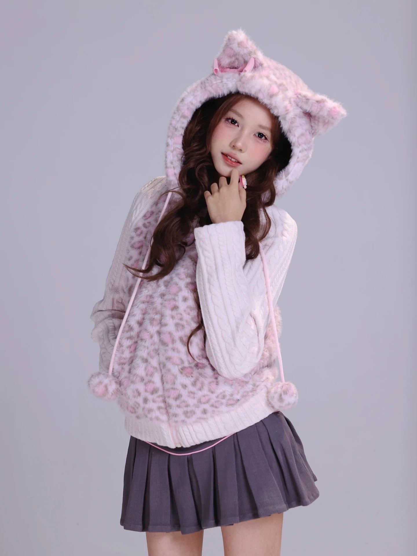 Girl wearing a pink hoodie with cat ears in fluffy faux fur fabric