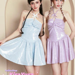 Two women wearing light blue and pink harajuku glitter dresses with a beige background.