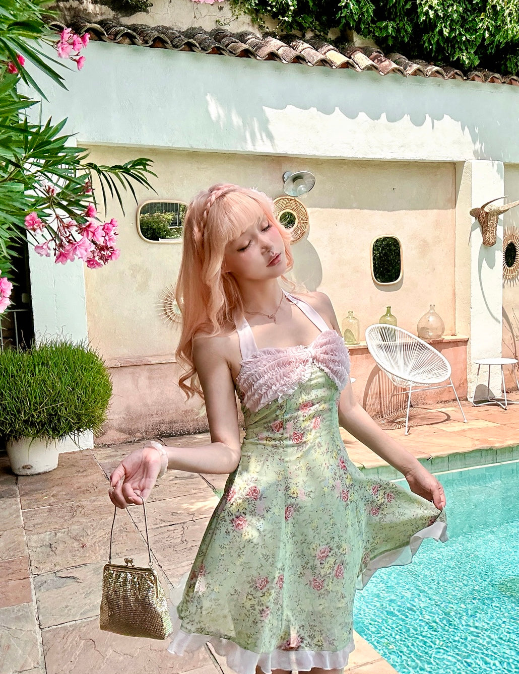 Pink hair girl wearing a floral dress standing by a pool with pastel colors