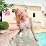 Woman in a floral dress standing by a pool with decorative elements.